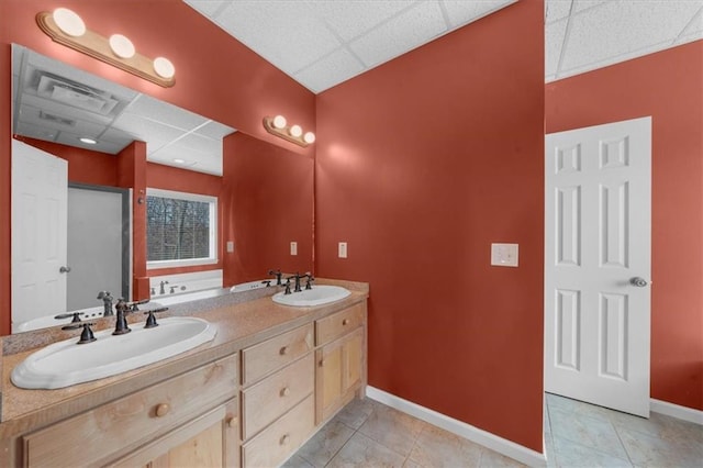 full bath with tile patterned flooring, baseboards, a drop ceiling, and a sink