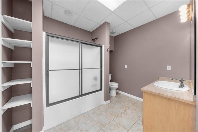 full bathroom with toilet, shower / bath combination with glass door, a paneled ceiling, baseboards, and vanity