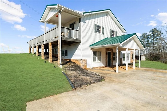 exterior space with a yard, driveway, and metal roof