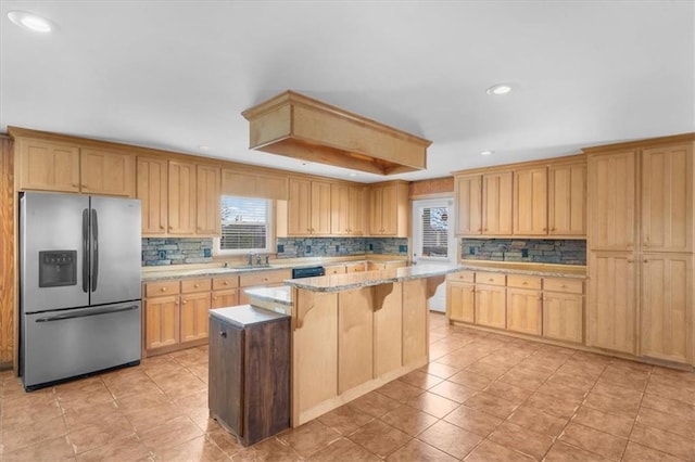 kitchen with a sink, decorative backsplash, a center island, and stainless steel fridge with ice dispenser