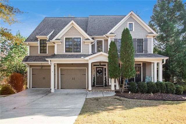 view of front of house featuring covered porch, a garage, and a front yard