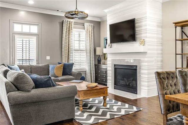 living room featuring ornamental molding, dark hardwood / wood-style flooring, and a high end fireplace