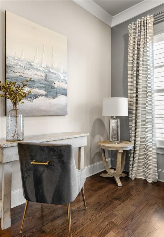 sitting room with crown molding, dark wood-type flooring, and a healthy amount of sunlight