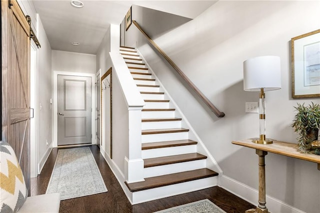 staircase featuring a barn door and hardwood / wood-style floors