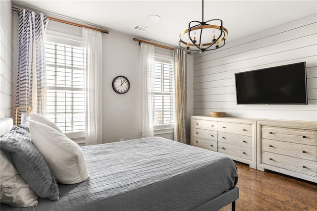 bedroom with dark hardwood / wood-style flooring and a chandelier