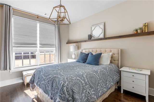 bedroom featuring dark wood-type flooring and a chandelier