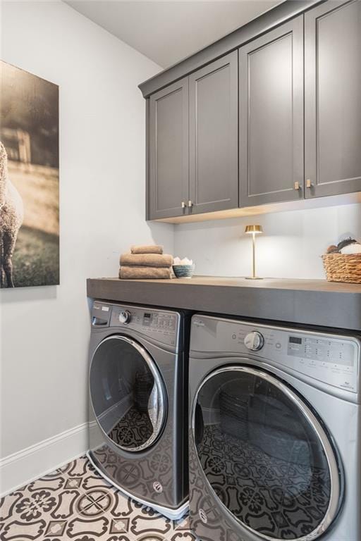 laundry room with cabinets, light tile patterned flooring, and washer and clothes dryer