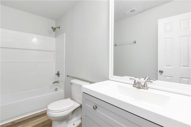 full bathroom with hardwood / wood-style floors, vanity, toilet, and bathtub / shower combination