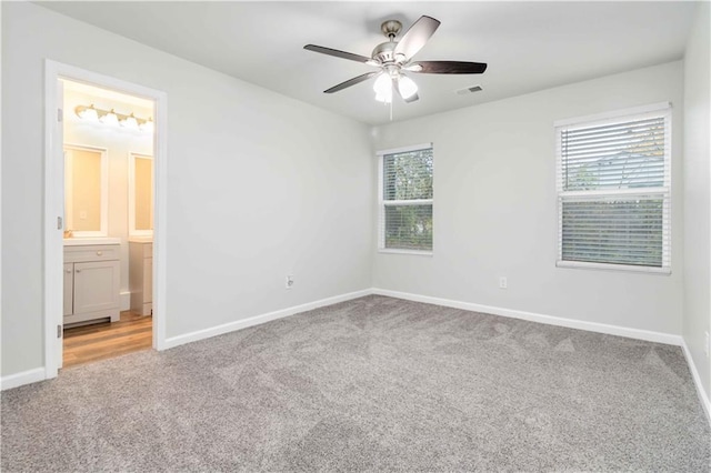 unfurnished bedroom featuring carpet flooring, ceiling fan, and ensuite bath