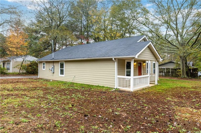 view of side of property with a lawn and a porch