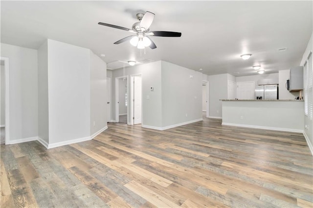 unfurnished living room featuring ceiling fan and wood-type flooring