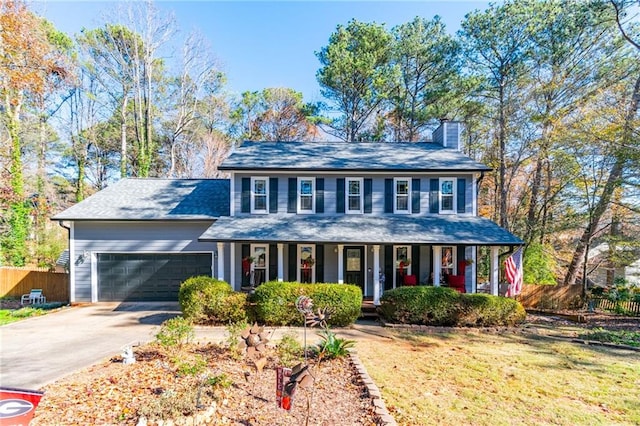 colonial inspired home featuring covered porch, a front yard, and a garage