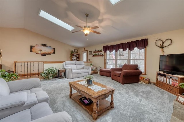 living room with carpet flooring, vaulted ceiling with skylight, and a ceiling fan