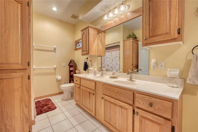 bathroom featuring tile patterned floors, visible vents, toilet, and a sink