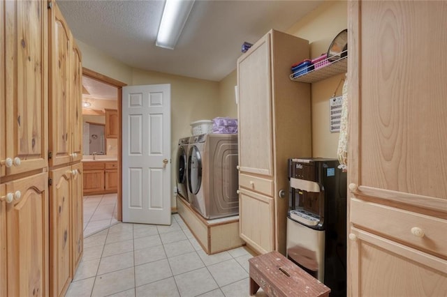 laundry room with light tile patterned floors, washing machine and dryer, laundry area, and a textured ceiling