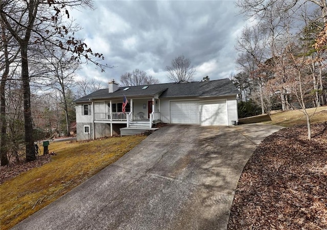 ranch-style home featuring a porch, concrete driveway, a garage, and a front lawn
