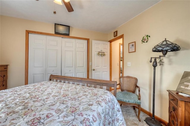 carpeted bedroom featuring a closet, baseboards, and a ceiling fan