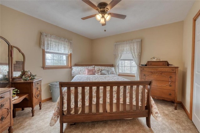 bedroom featuring baseboards, light colored carpet, and ceiling fan