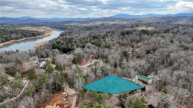 aerial view featuring a water and mountain view and a wooded view