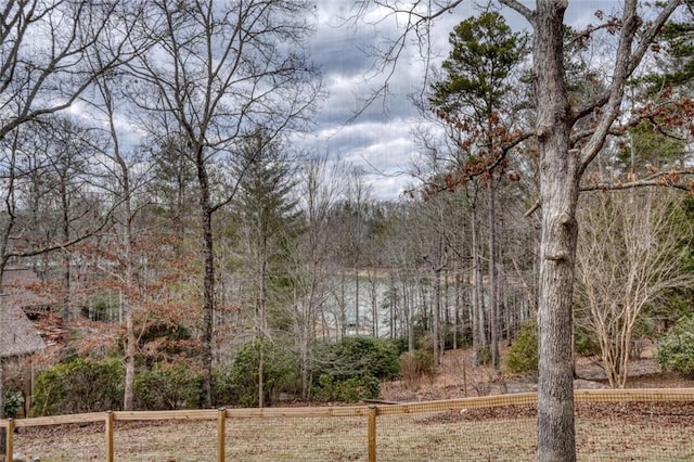 view of yard featuring fence and a view of trees