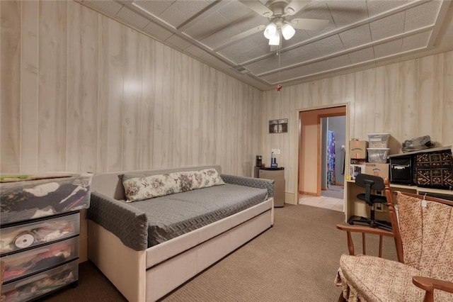 bedroom with carpet floors, wooden walls, and ceiling fan