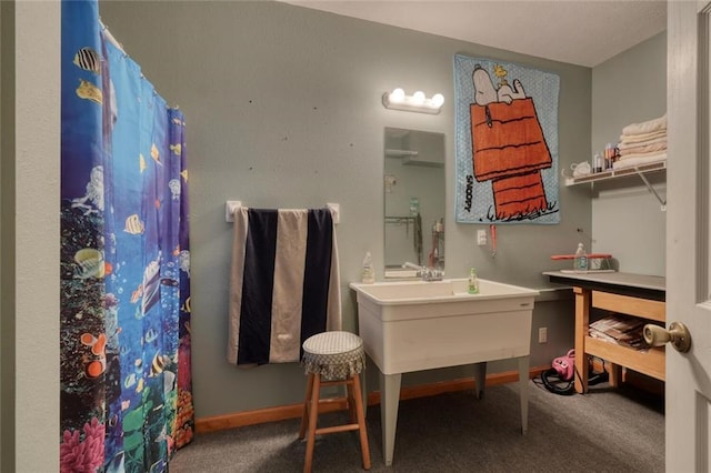 bathroom featuring baseboards, a shower with shower curtain, and vanity