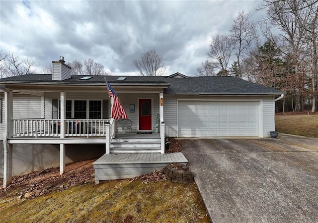 ranch-style house featuring an attached garage, a chimney, concrete driveway, and a porch