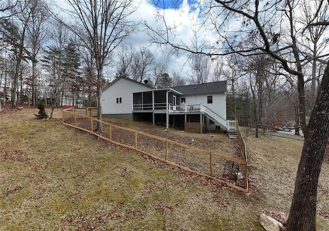back of property featuring a sunroom, fence, stairs, and a deck
