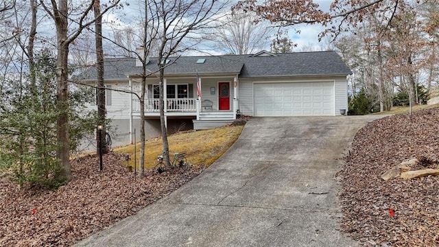 ranch-style house with a shingled roof, covered porch, a garage, and concrete driveway