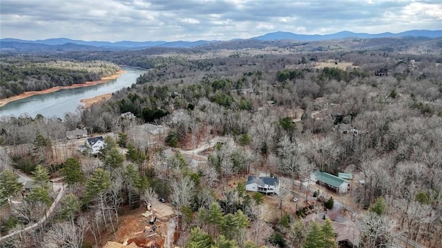 aerial view with a water and mountain view and a view of trees