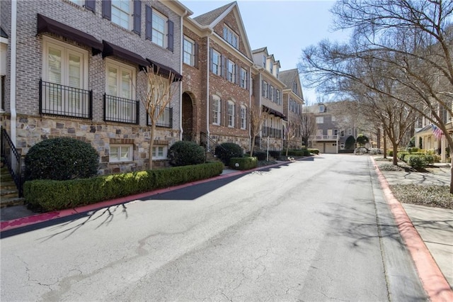 view of road with a residential view and curbs