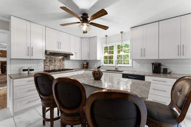 kitchen featuring white cabinetry, sink, decorative light fixtures, and light stone countertops