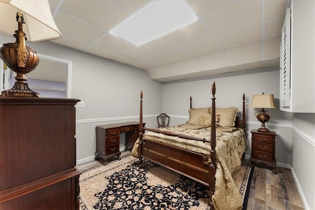 bedroom featuring hardwood / wood-style floors and a drop ceiling