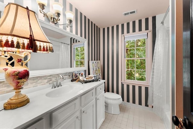 bathroom featuring vanity, toilet, and tile patterned flooring