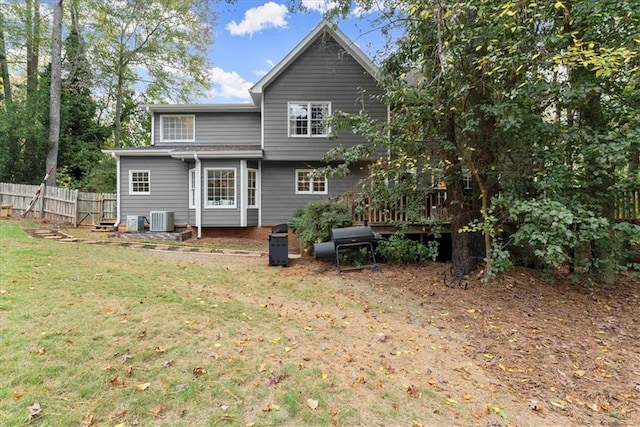 back of house with cooling unit and a lawn