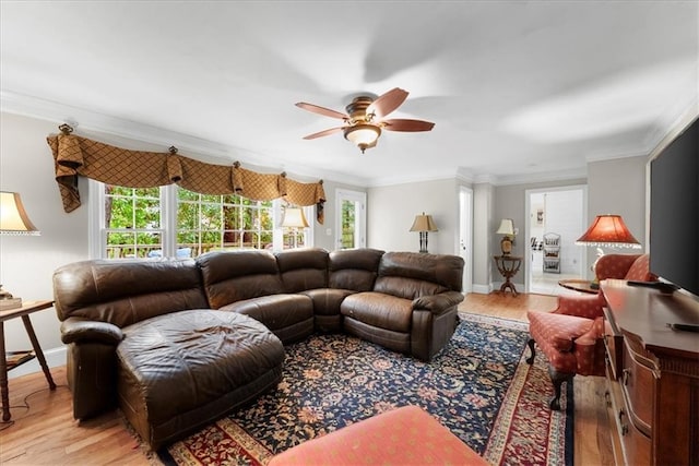 living room featuring crown molding, light hardwood / wood-style flooring, and ceiling fan