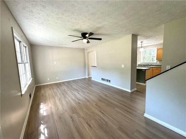 unfurnished room featuring ceiling fan, sink, hardwood / wood-style floors, and a textured ceiling