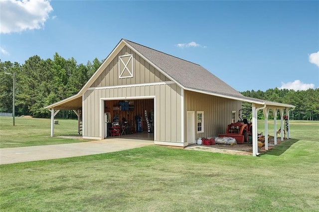 view of outbuilding featuring a garage, a lawn, and a carport