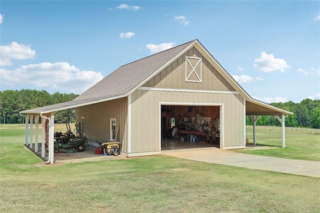 view of outbuilding with a garage, a lawn, and a carport