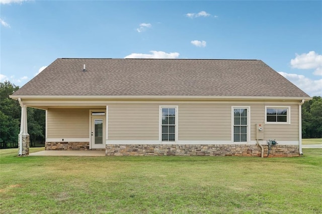 rear view of property featuring a patio and a lawn