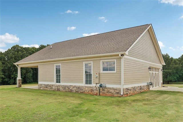 back of house featuring a garage and a lawn