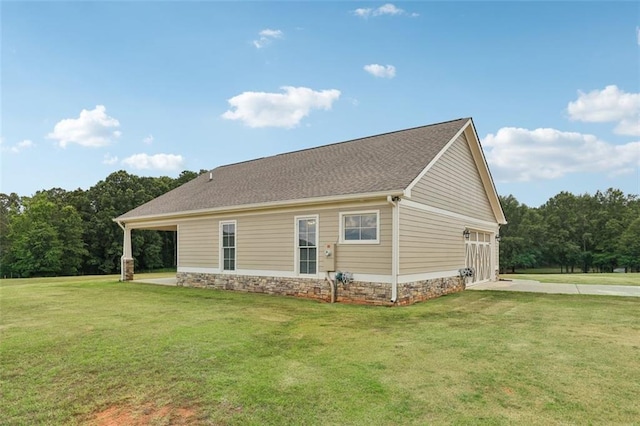 view of side of home with a garage and a lawn