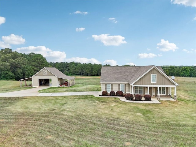 view of front of home featuring a garage, covered porch, an outbuilding, and a front yard