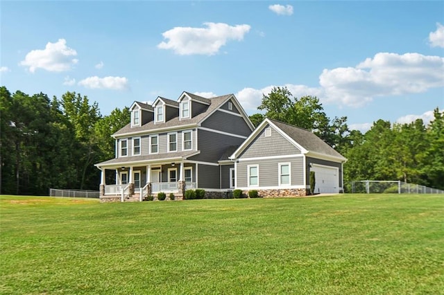 view of front of home with covered porch, a front yard, and a garage