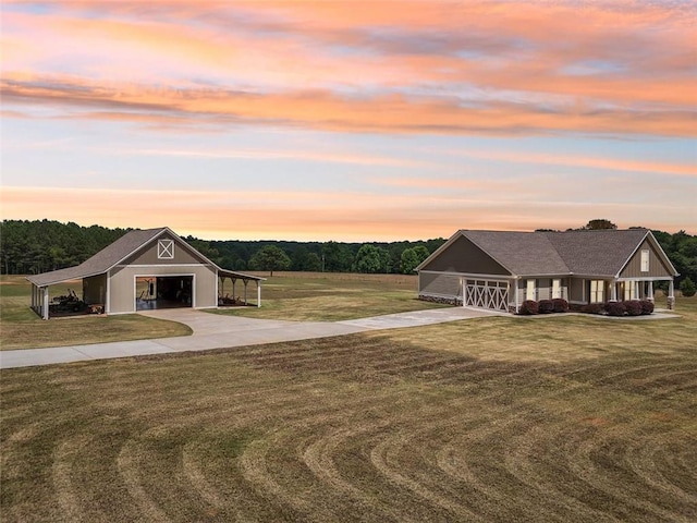 view of front of home with a garage, a lawn, an outbuilding, and a carport