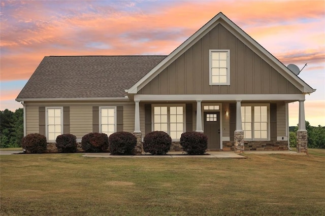 view of front of property with covered porch and a lawn