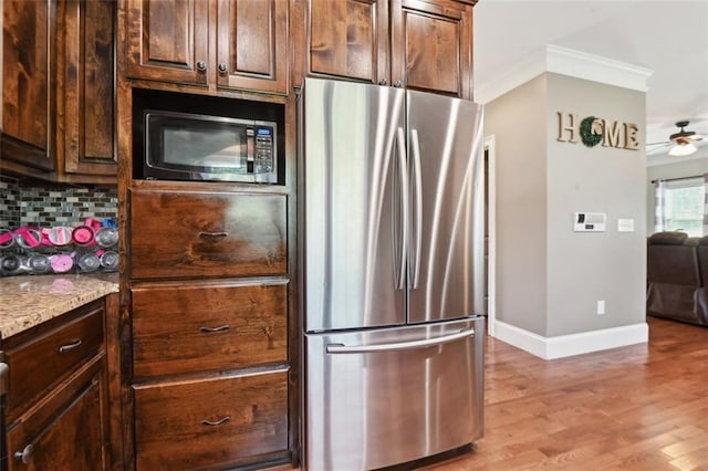 kitchen featuring dark brown cabinetry, stainless steel refrigerator, ornamental molding, and tasteful backsplash