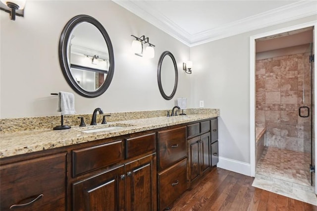 bathroom with vanity, a shower with shower door, crown molding, and hardwood / wood-style floors