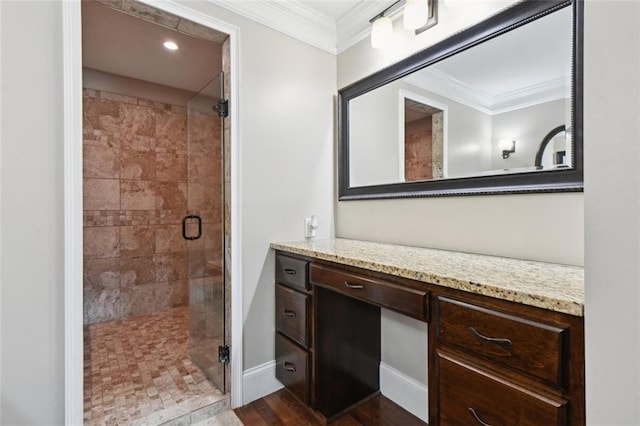 bathroom with wood-type flooring, vanity, a shower with shower door, and ornamental molding