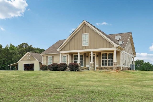 craftsman inspired home featuring cooling unit, a porch, a garage, a front lawn, and an outdoor structure